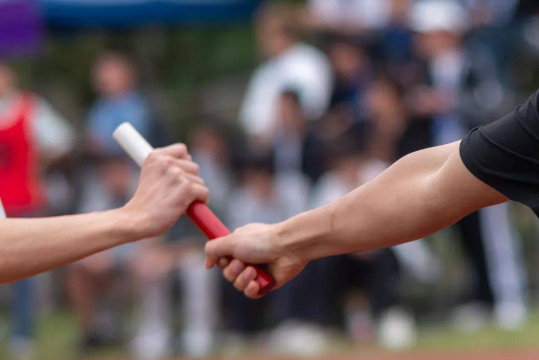 爱游戏官网-运动员们团结互助，共同握紧胜利的手